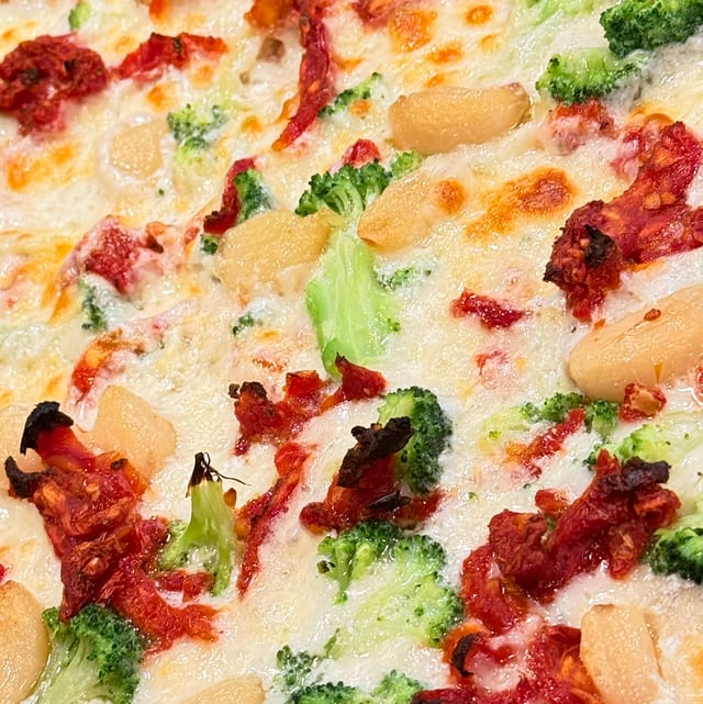 Broccoli & Roasted Garlic Deluxe Pizza.
