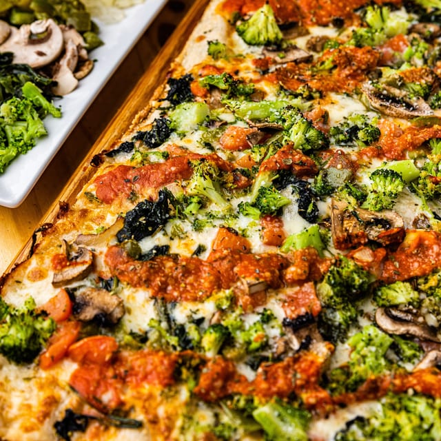 Broccoli & Roasted Garlic Deluxe Pizza.